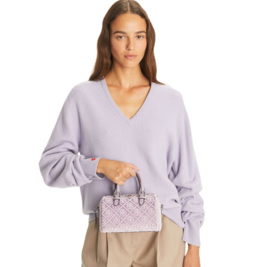 Lady Holding Top Handle of T Monogram Barrel Bag with