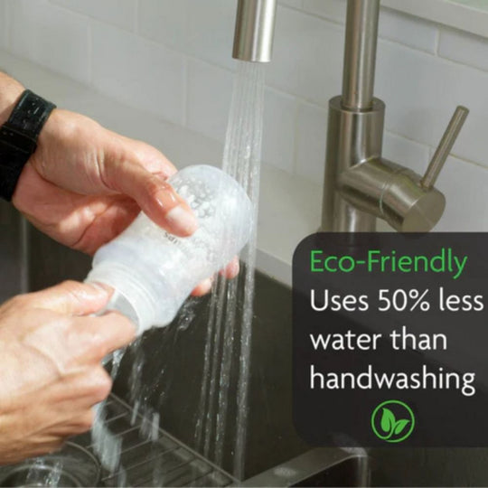 Person handwashing a baby bottle under a faucet with text highlighting its water efficiency of Baby Brezza Bottle Washer Pro which is better than handwashing.