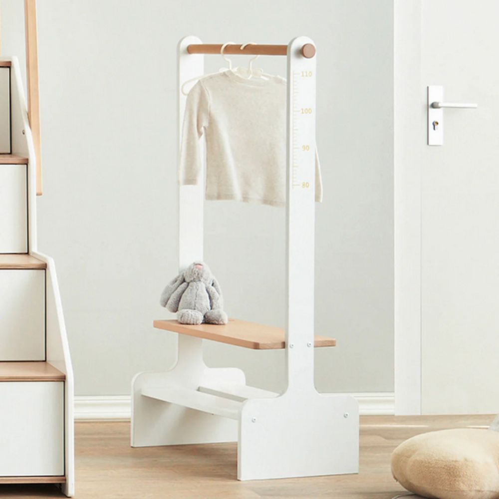 White standing mirror with wooden top and base in a minimalistic room.