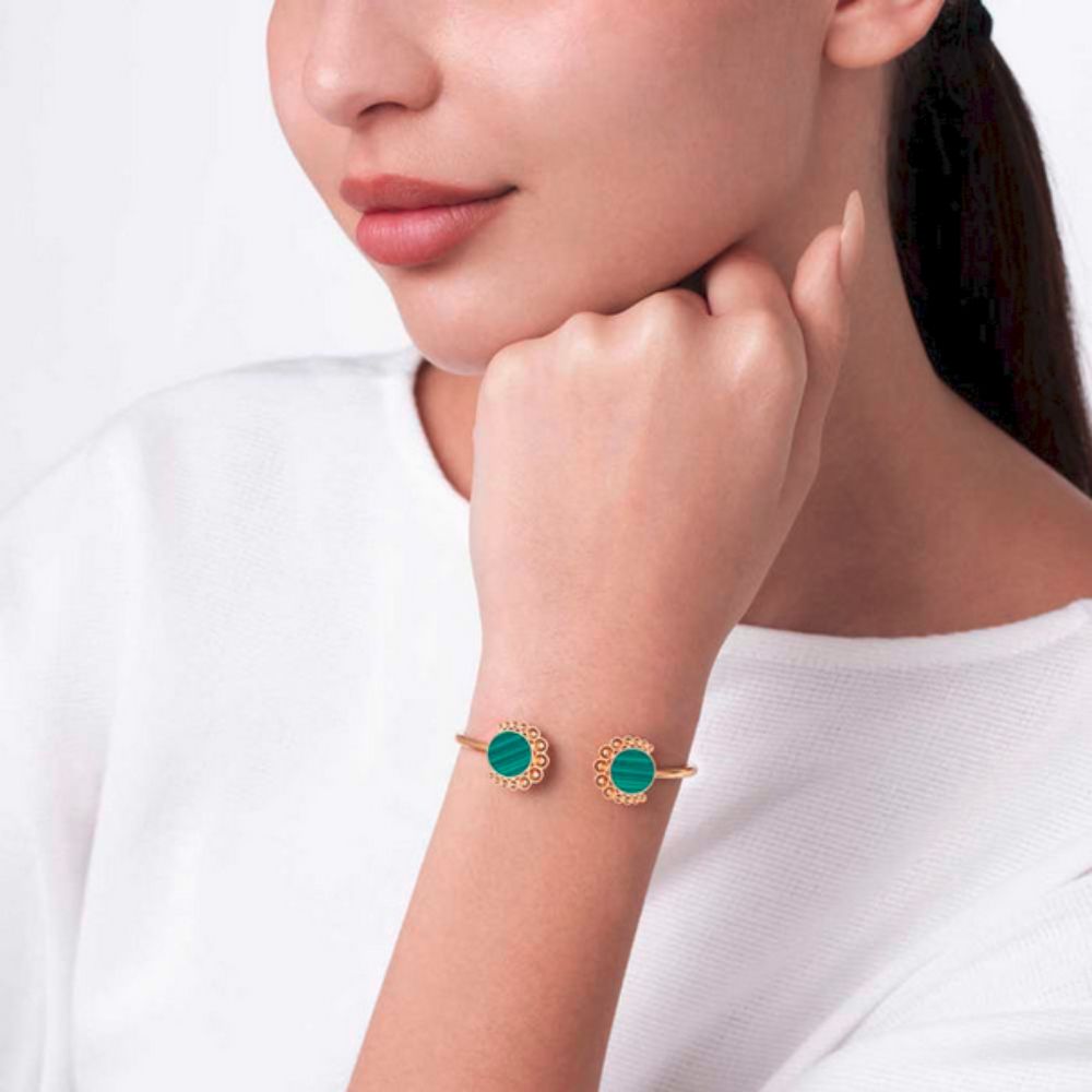 A model displaying the Bint Al Matar Yellow Gold Malachite Bangle on her wrist