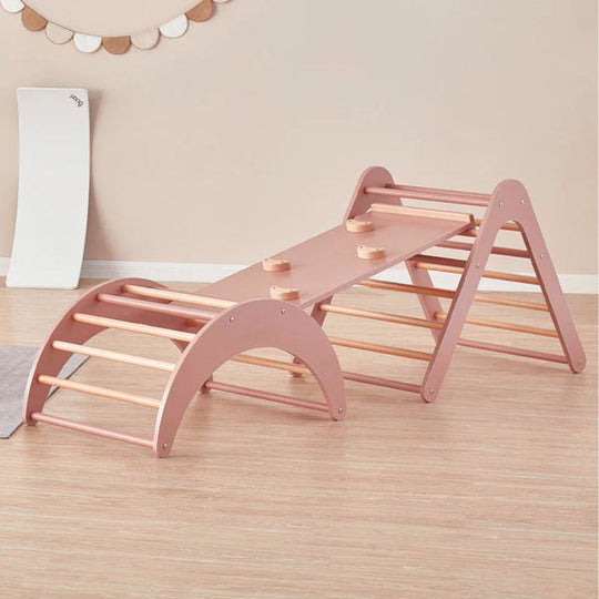 Pink wooden climbing toy on a wooden floor with a neutral wall background