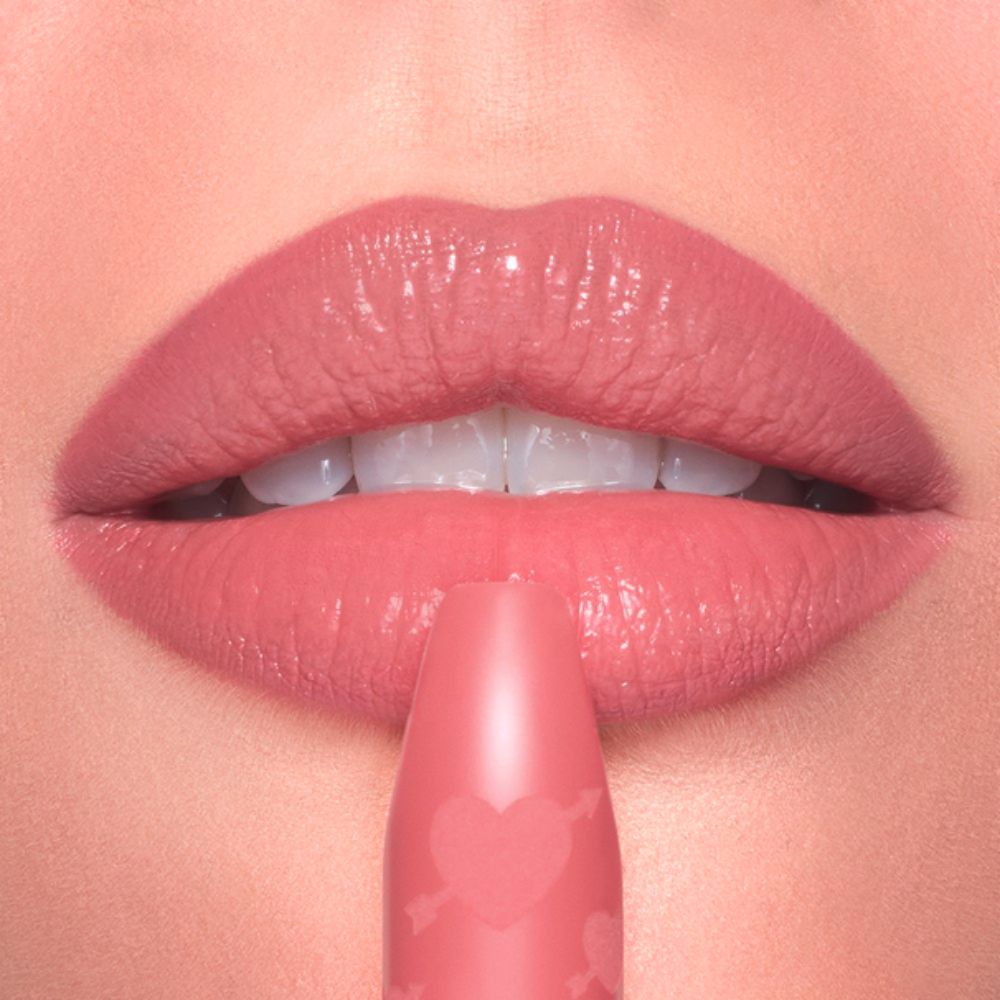 Close-up of lips being touched with a Charlotte Tilbury Pillow Talk Love Effect Lipstick Matte Revolution - Naughty Talk lipstick.