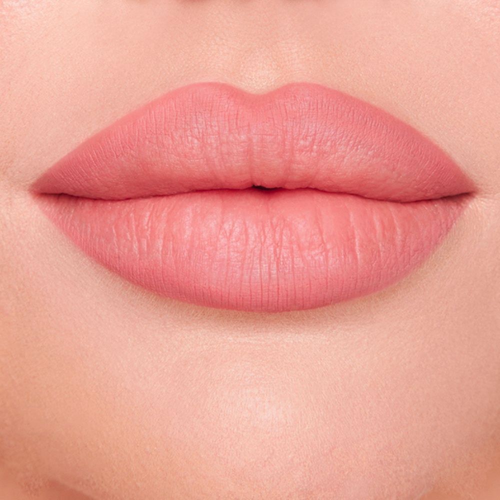 A close-up view showcases full lips adorned with a matte, dusty rose lipstick, highlighting the smooth texture and even application of the product.
