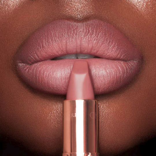 A close-up shot features a person applying Charlotte Tilbury Matte Revolution Lipstick.