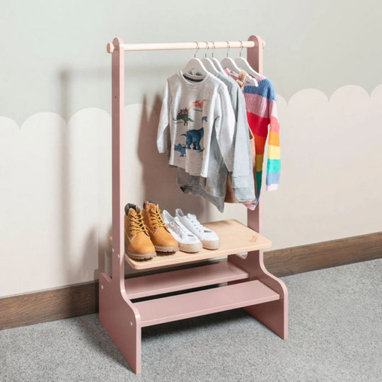 Children's Pink coat rack with clothes and shoes on a light gray background