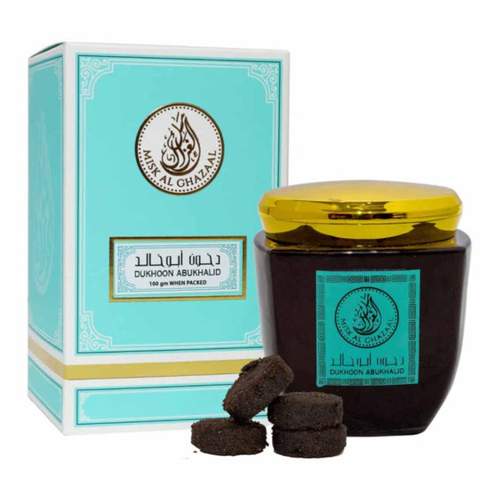 100g container of Dukhoon Abu Khalid by Misk Al Ghazaal with Some Dukhoon and Its Box kept besides it