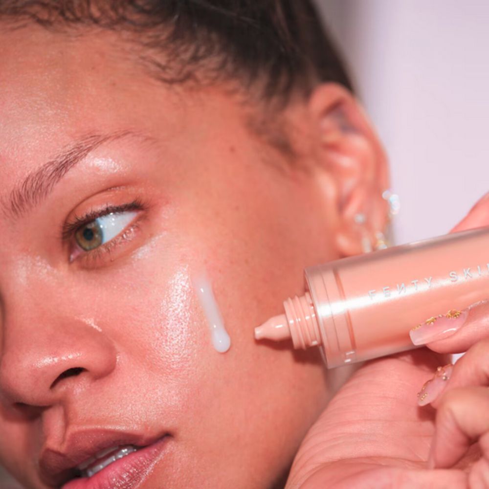Close of Rihanna's face as she applies FENTY SKIN  Watch Ya Tone Niacinamide Dark Spot Serum