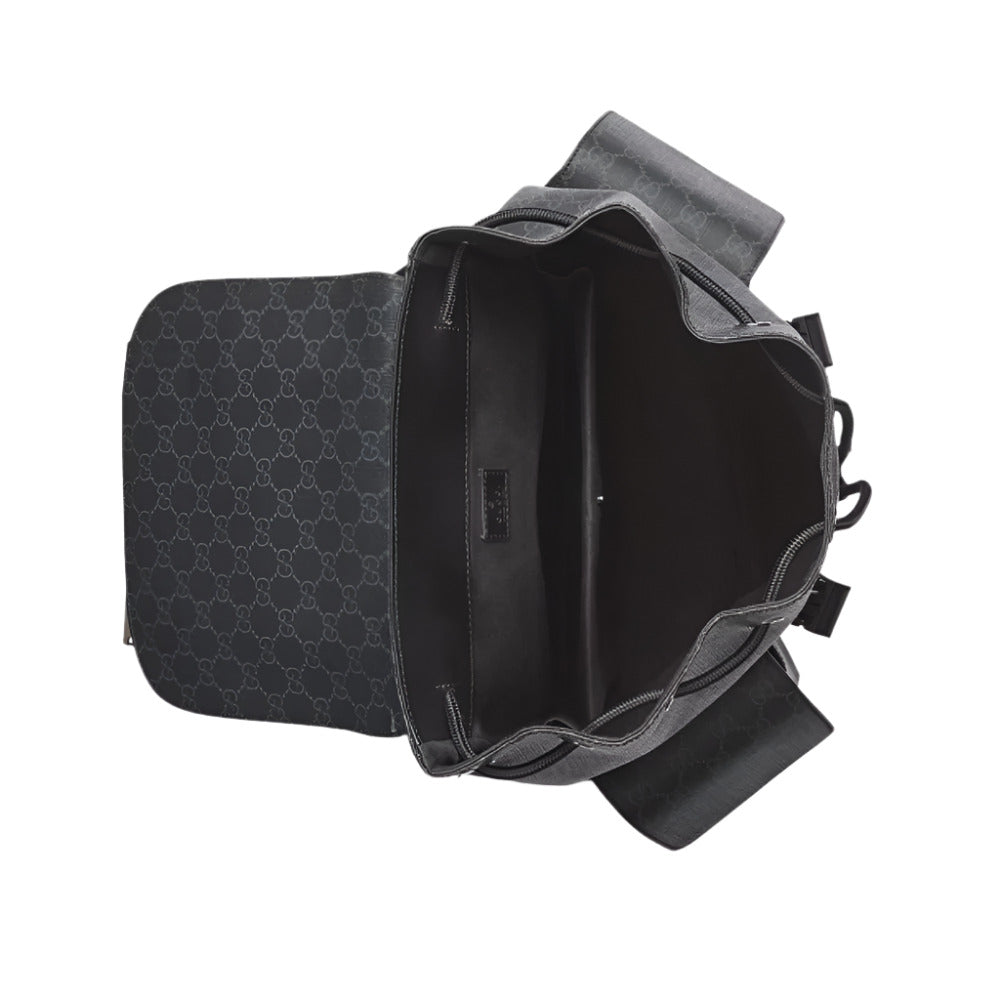 A top-down view of an open GUCCI Chroma Large Backpack in black, showcasing the GG Supreme canvas pattern. The main compartment is open, revealing the black lining and an internal padded laptop sleeve. The flap is open and laid flat, and the two side pockets are also visible.