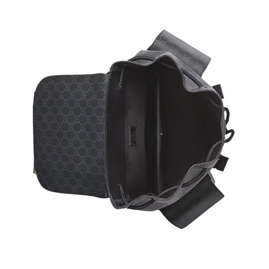 A top-down view of an open GUCCI Chroma Large Backpack in black, showcasing the GG Supreme canvas pattern. The main compartment is open, revealing the black lining and an internal padded laptop sleeve. The flap is open and laid flat, and the two side pockets are also visible.