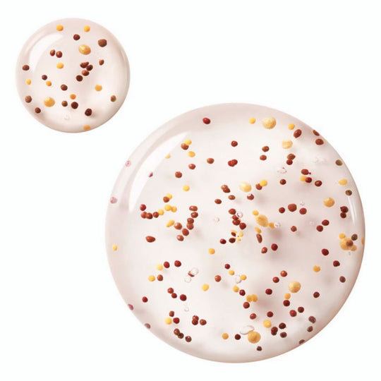 Two drops of Givenchy Mister Healthy Glow Gel containing small red, yellow, and brown pigmented beads.