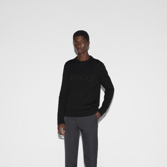 Model styled Gucci cashmere sweater with gray trousers