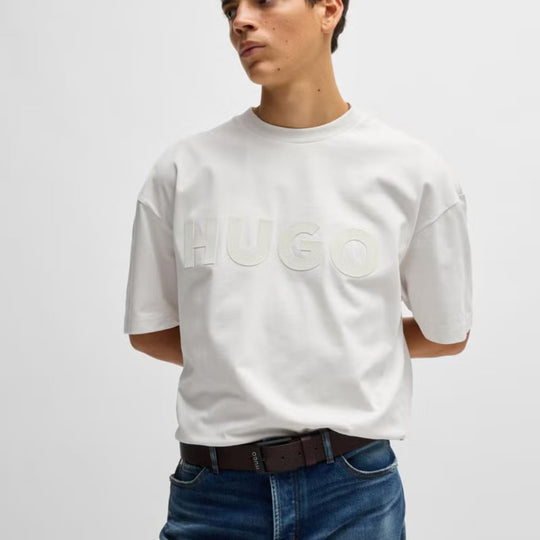 A model wearing Hugo Men's Smooth Dark Brown Leather Belt with Matte Black Buckle