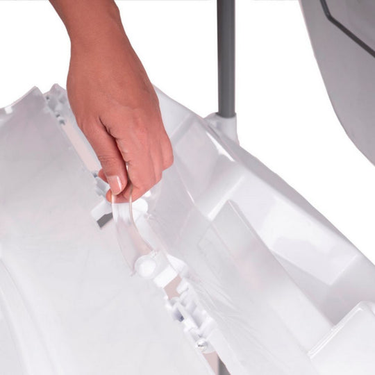 Hand holding a clear plastic bag over a white surface