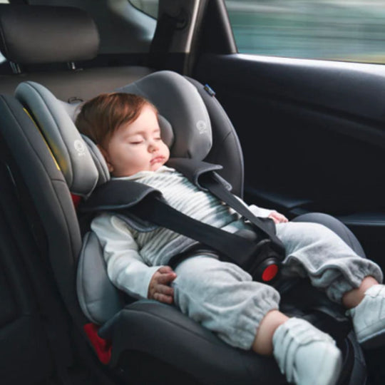Child sleeping in a car seat with a blurred background