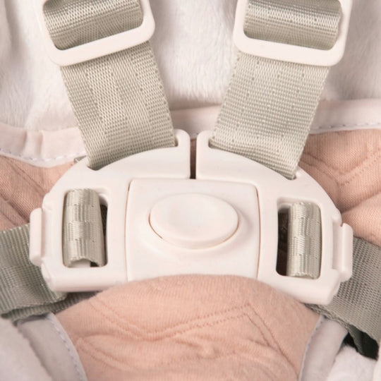 Close-up of a white plastic buckle on gray straps with a blurred background.
