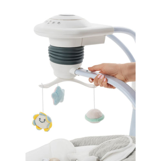 Baby crib mobile with cloud and star decorations, held by a hand against a white background