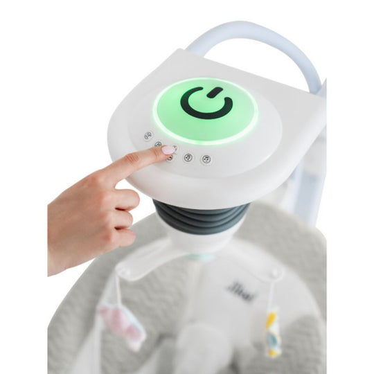 Hand pressing a power button on a white device with a green light