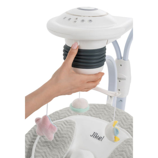 Hand holding a baby mobile with 'Jikel' branding on a white background