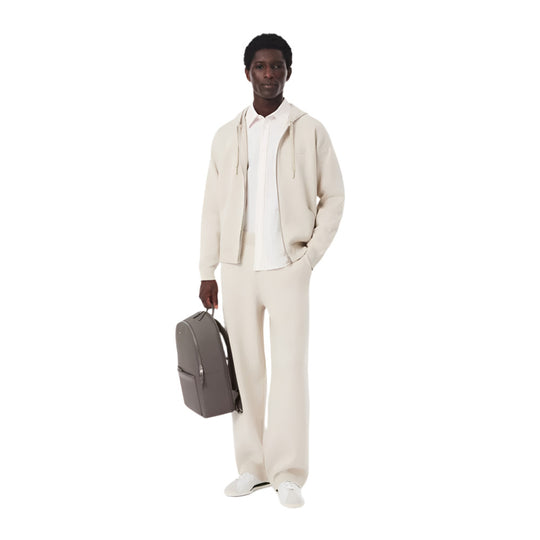 A black model standing with LACOSTE Chantaco Pique Leather Brown Backpack in his hand