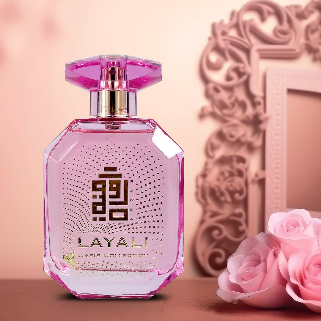 A  EDP 110mL bottle of Layali fragrance by Rawda kept on a table besides Pink Roses