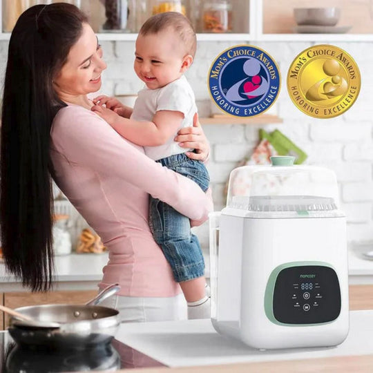 Woman holding a child next to a Momcozy KleanPal Pro Automatic Baby Bottle Washer with awards displayed