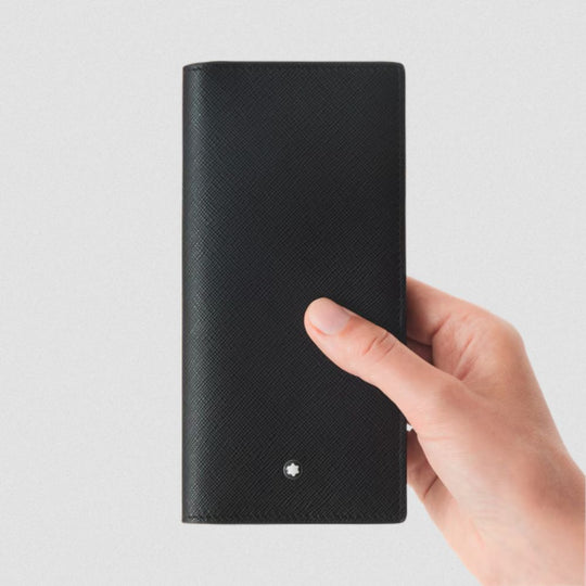 Hand holding a black textured wallet with a brand logo on a light gray background