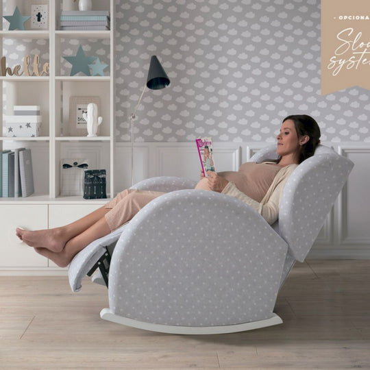 Woman relaxing in a Micuna Flor Slow System Rocking Chair in a home setting.