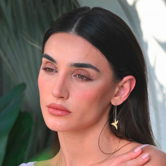 A model showing Moiseau Gold Threader Hummingbird Earrings with Chain