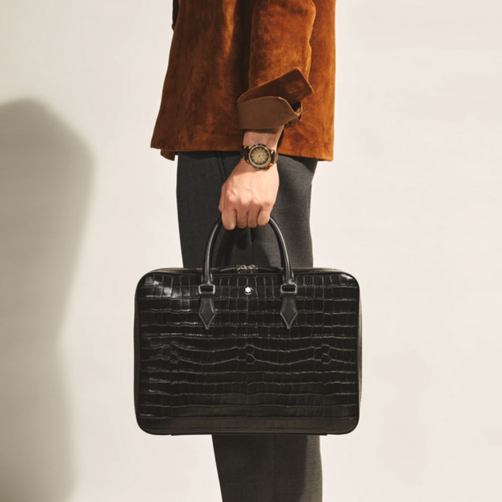 Person holding aMontblanc Atelier Luxury Business Organizer in Black Leather  against a neutral background