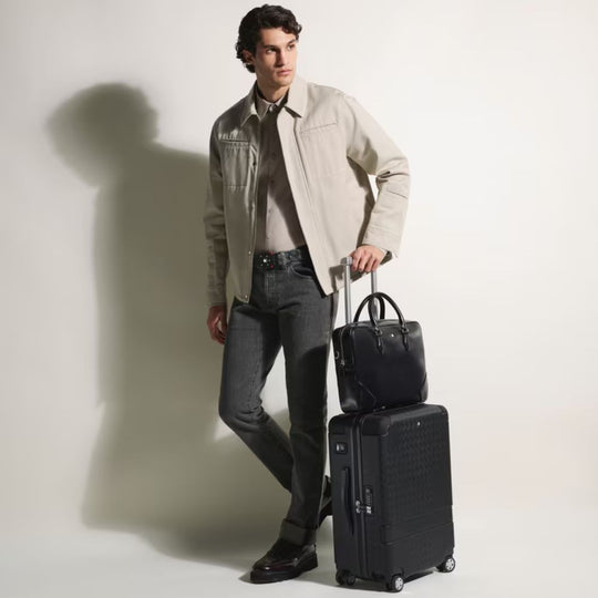 Man holding a Montblanc MY4810 Luxury Cabin Trolley Bag and briefcase against a plain background