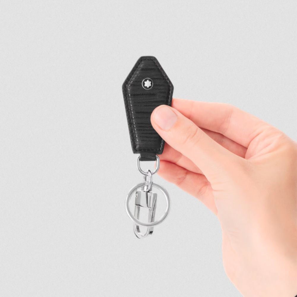 Hand holding a black keychain with a silver ring