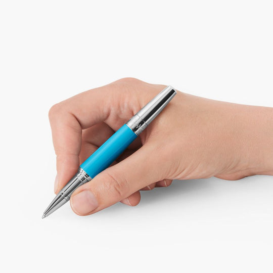 A hand writing with a Montblanc Muses Maria Callas Special Edition Rollerball pen against a white background.