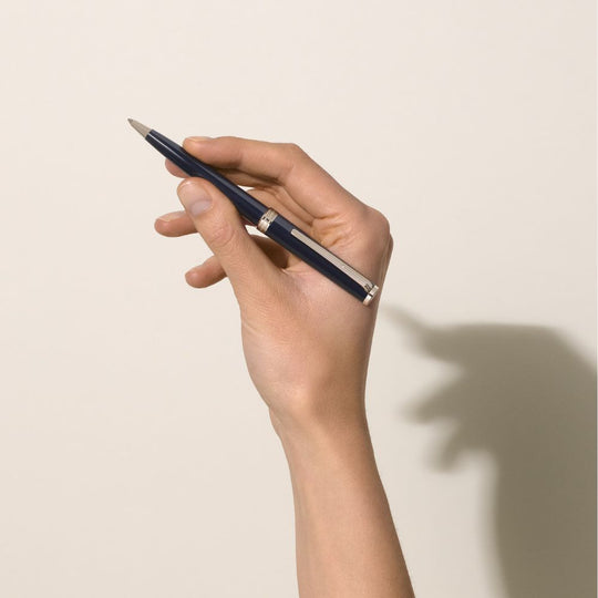 A hand holding a Montblanc Pix Blue Ballpoint Pen.