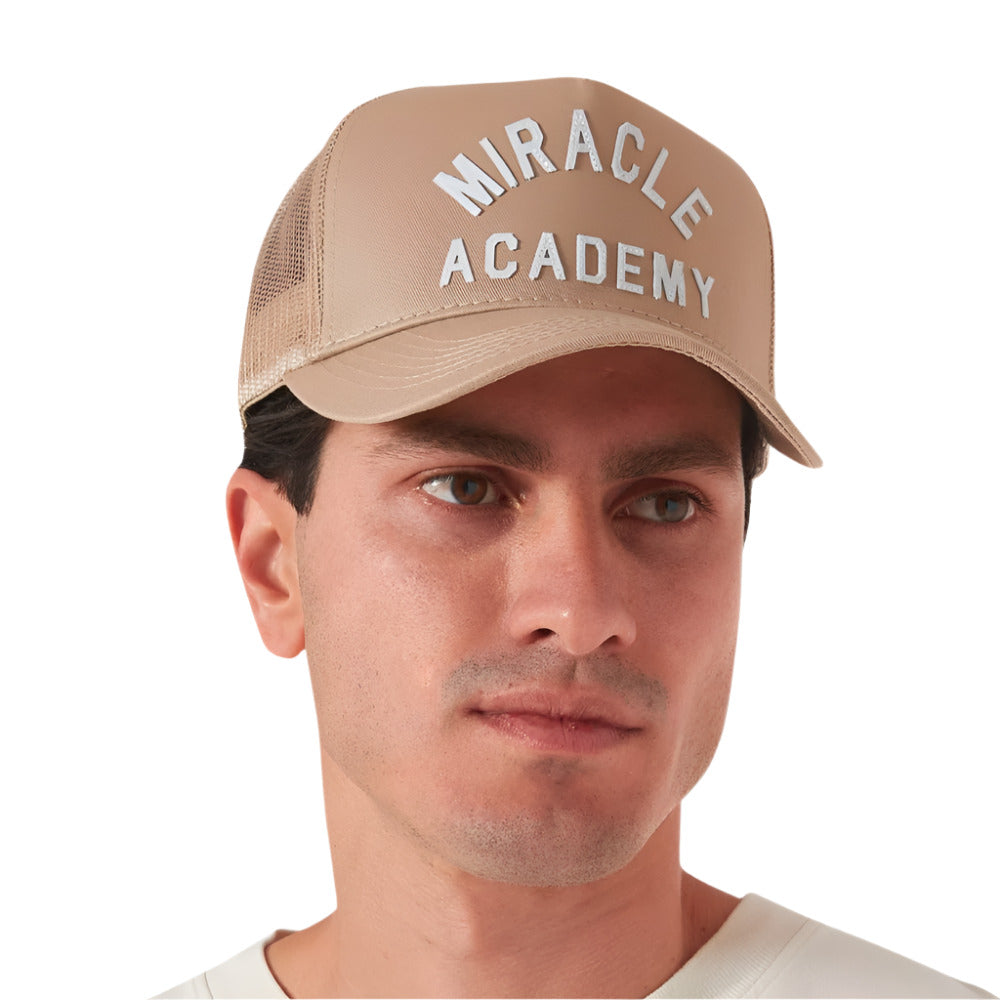 A model wearing of Nahmias Miracle Academy Beige Trucker Cap with Mesh Back