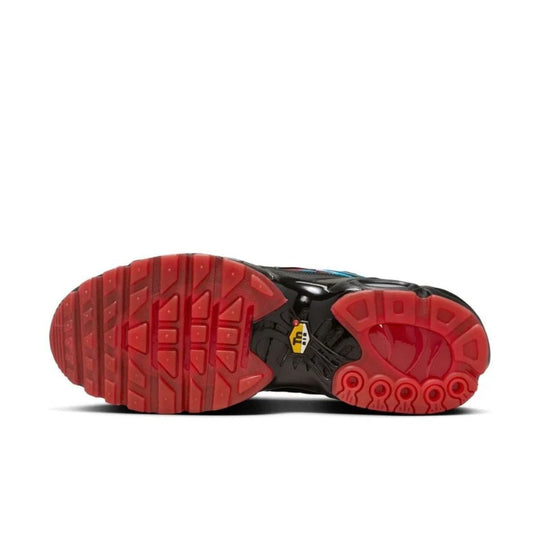 A bottom view of the Nike Air Max Plus "Shark Attack" sneakers, featuring a red rubber outsole with a waffle pattern