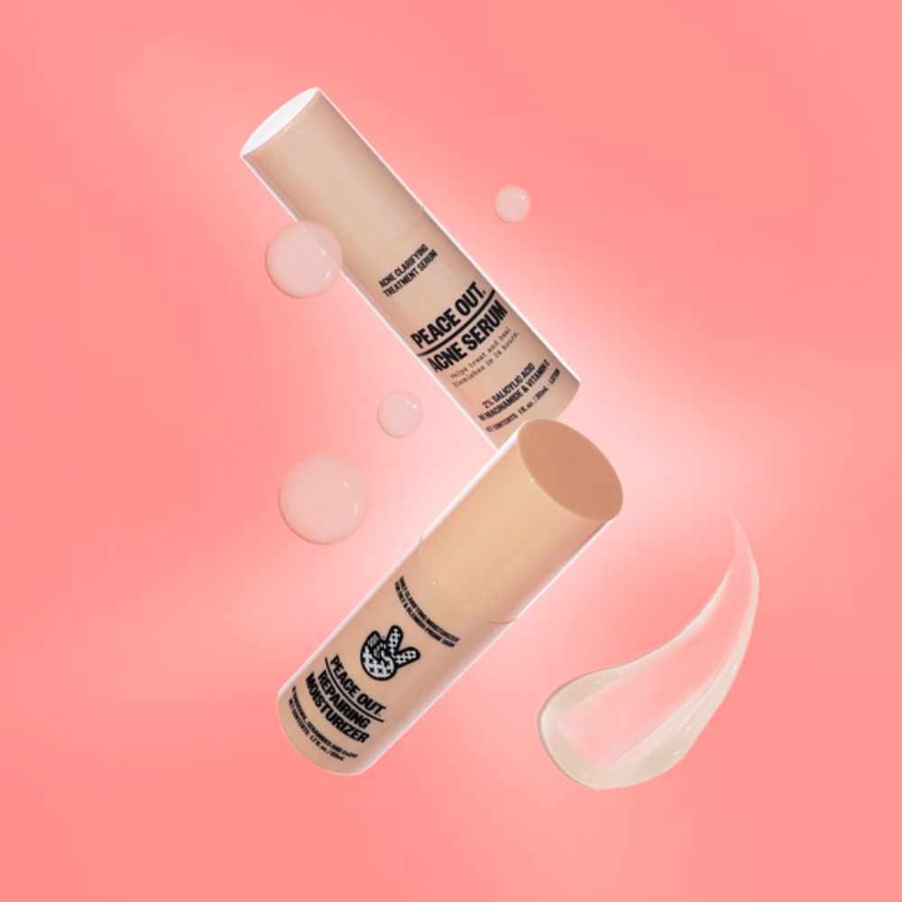 Two light peach-colored bottles, Peace Out Acne Serum and Peace Out Repairing Moisturizer, float diagonally on a pink background with floating bubbles and a smear of product.