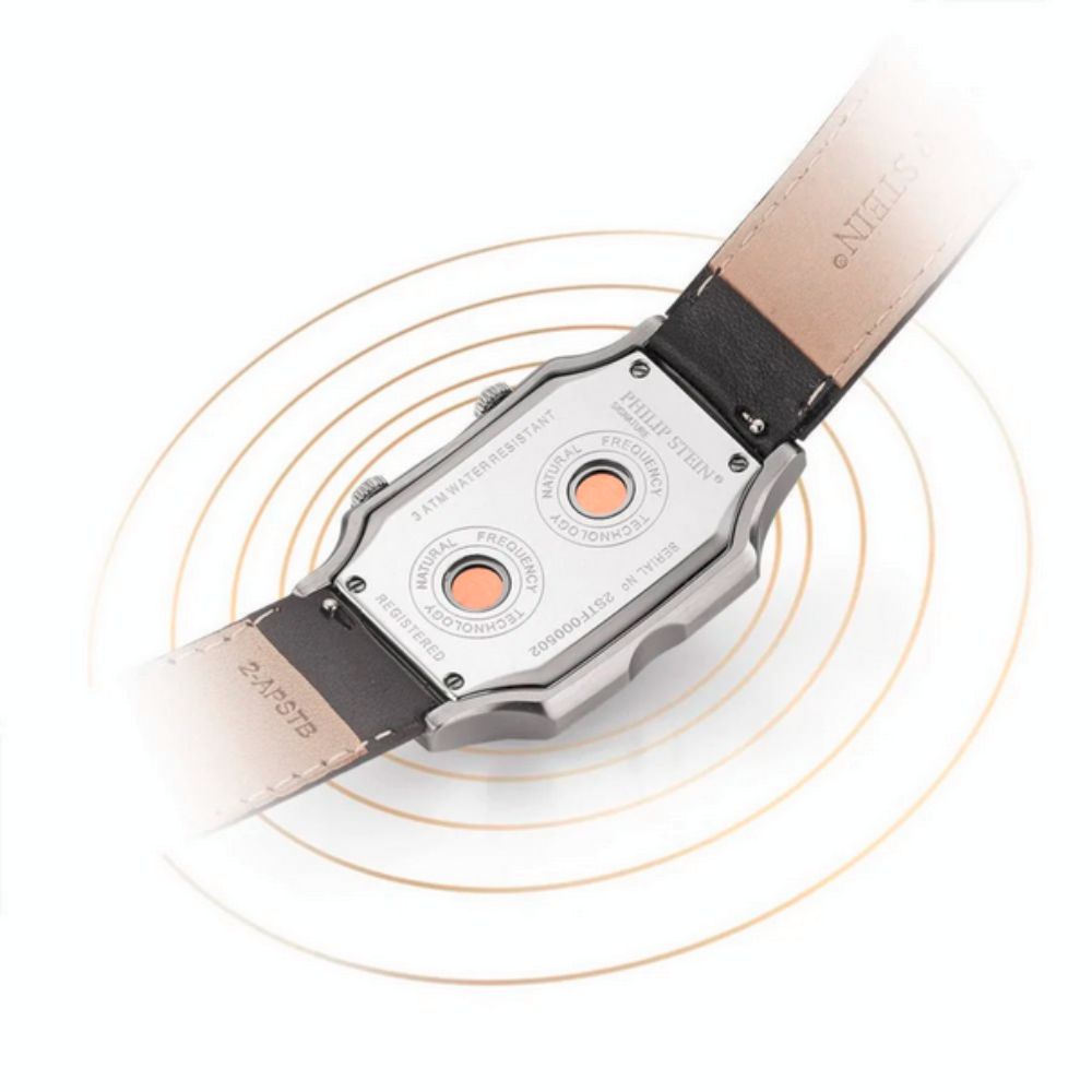 Close-up of the case back of a Philip Stein Signature Slim 27mm women's quartz watch, showing the silver finish, "Natural Frequency Technology" inscription, and a black leather strap partially visible.