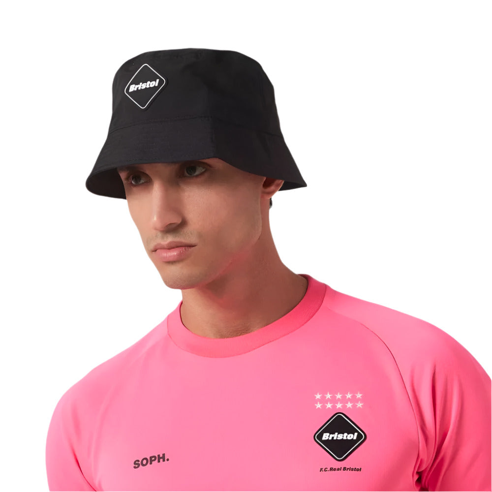 A model wearing Paperboy Paris x FCRB Black Bucket Hat