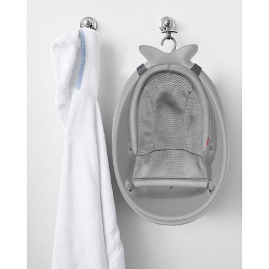 Gray baby seat with shark design hanging on a hook against a white background