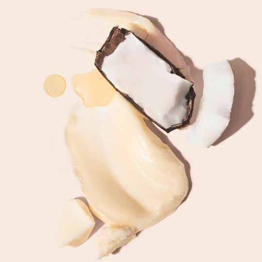 Swatch of a creamy product with pieces of coconut and oil droplets.