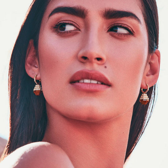 A model displaying Samra Azm Yellow Gold Tiger Eye Earring on her ears
