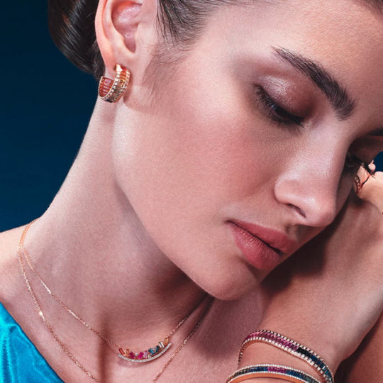 A model showing the Samra Noor Rose Gold Sapphire Hoop Earring on her ear