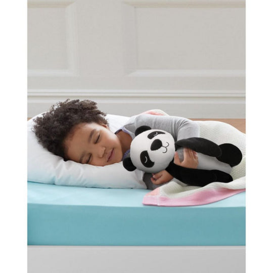 Child sleeping on a mattress with a panda plush toy