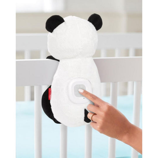 Panda-shaped night light attached to a crib with a hand pressing a button.