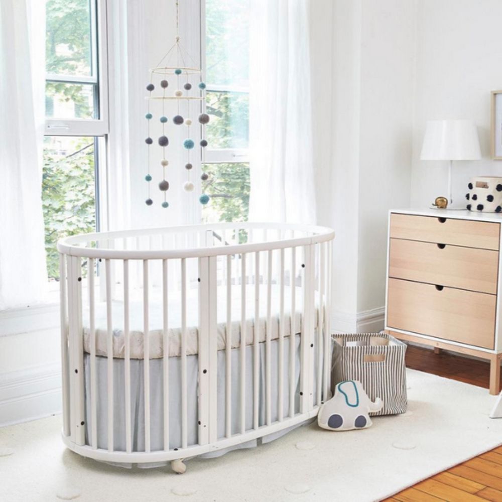 Stokke Sleepi Bed White in a bright nursery with a dresser and window