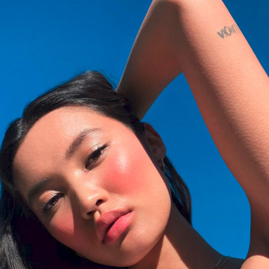 A lady model showing off the effect of Urban Decay All Nighter Ultra Glow Setting Spray on her skin