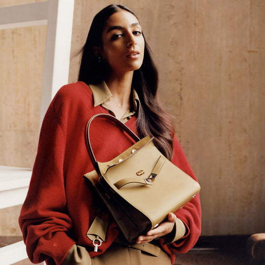 Model in Red Woollen V-Neck Sweater Holding a Bag