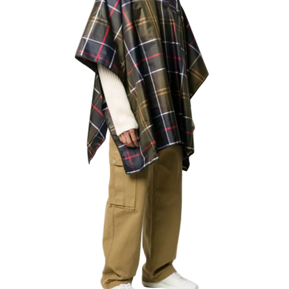 Person wearing a plaid poncho and beige pants on a white background