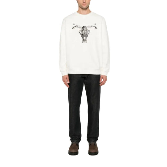 Person wearing a white sweater with a graphic design on a white background