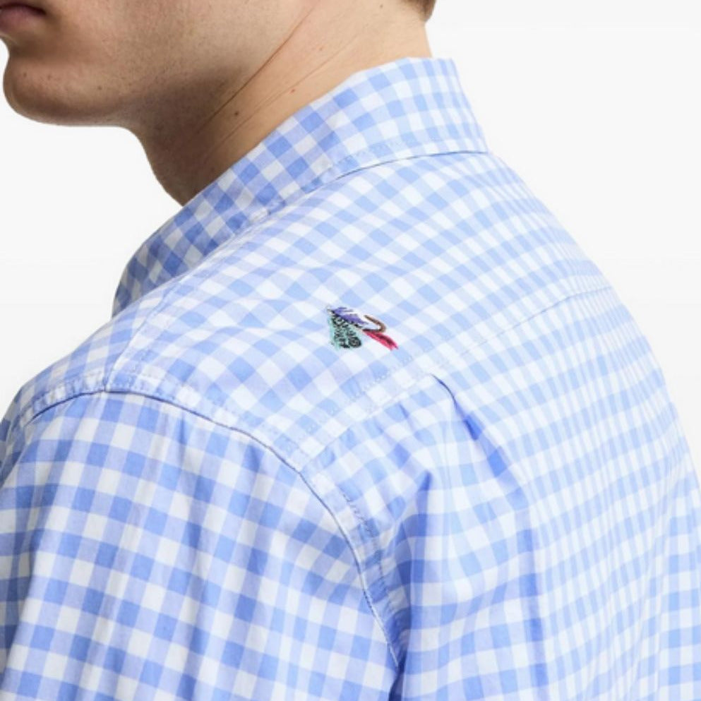 Close-up of a blue and white checkered shirt with a brand logo on a white background